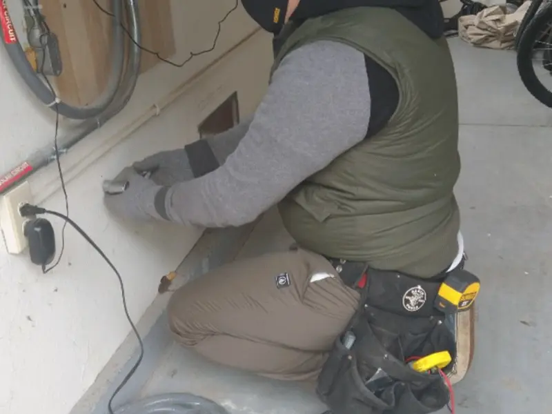 Electrician performing outlet wiring in a Forest Park garage